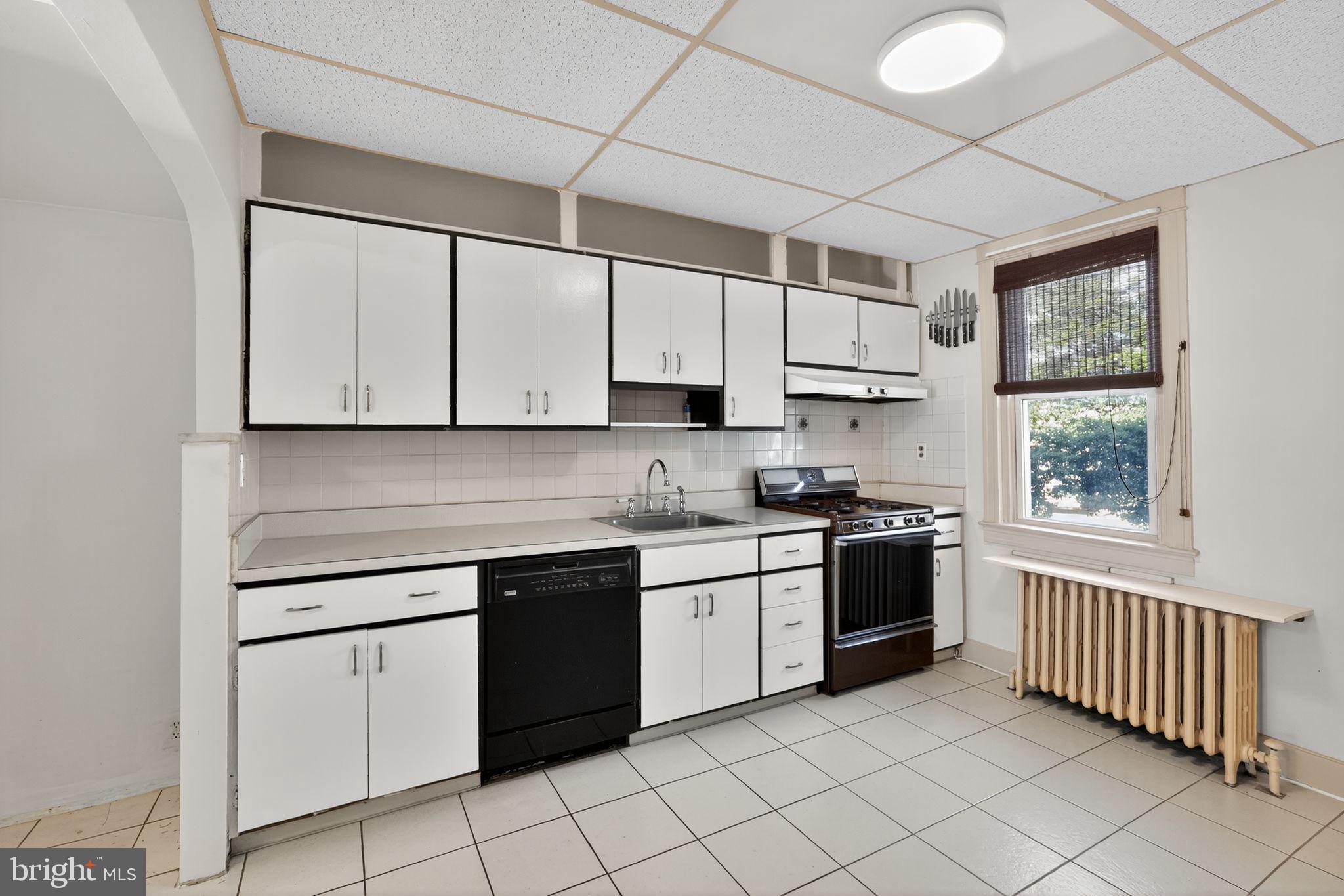 2919 Robbins Street Philadelphia, PA 19149 - Photo 15 of 32 a kitchen with a stove sink and cabinets
