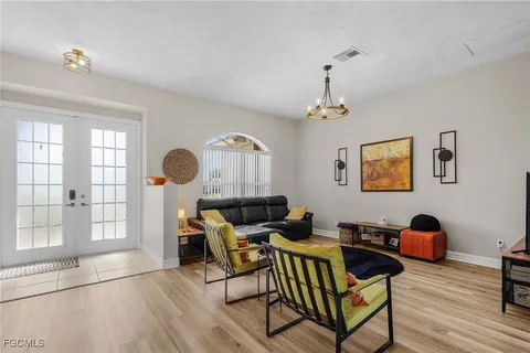 a living room with furniture a chandelier and a window