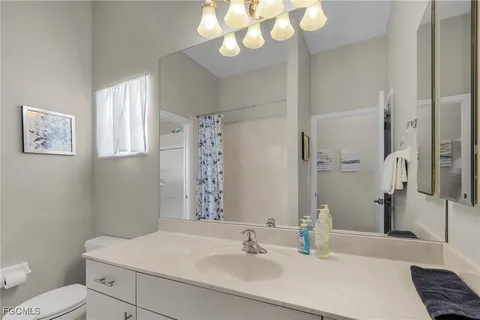 a bathroom with a sink a toilet and a mirror