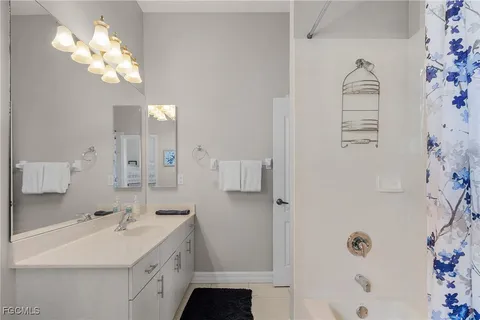 a bathroom with a sink a light fixture and a mirror