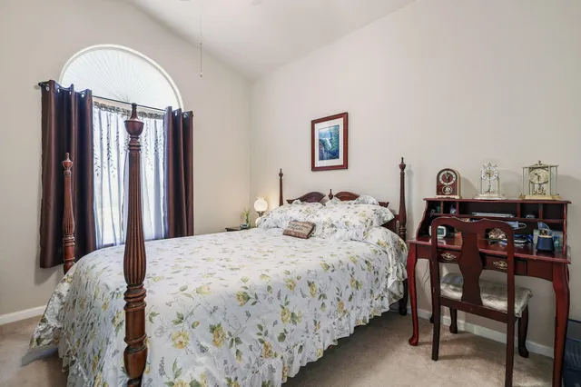 a bedroom with a bed a table and chair