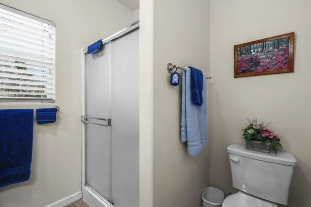 a bathroom with a toilet and a shower