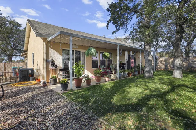 a view of a house with backyard porch and sitting area
