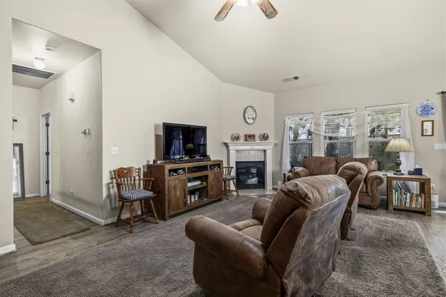 a living room with furniture a fireplace and a flat screen tv