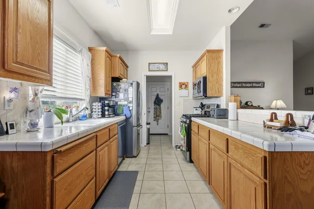 a large kitchen with stainless steel appliances lots of counter space and a sink