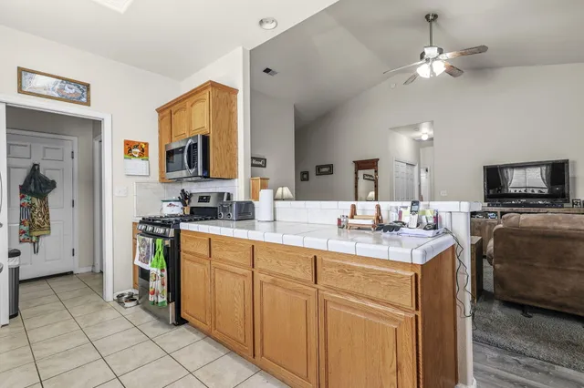 a kitchen with stainless steel appliances kitchen island granite countertop a sink and cabinets