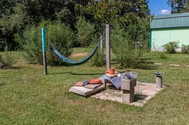 a view of a backyard with table and chairs potted plants and a palm tree