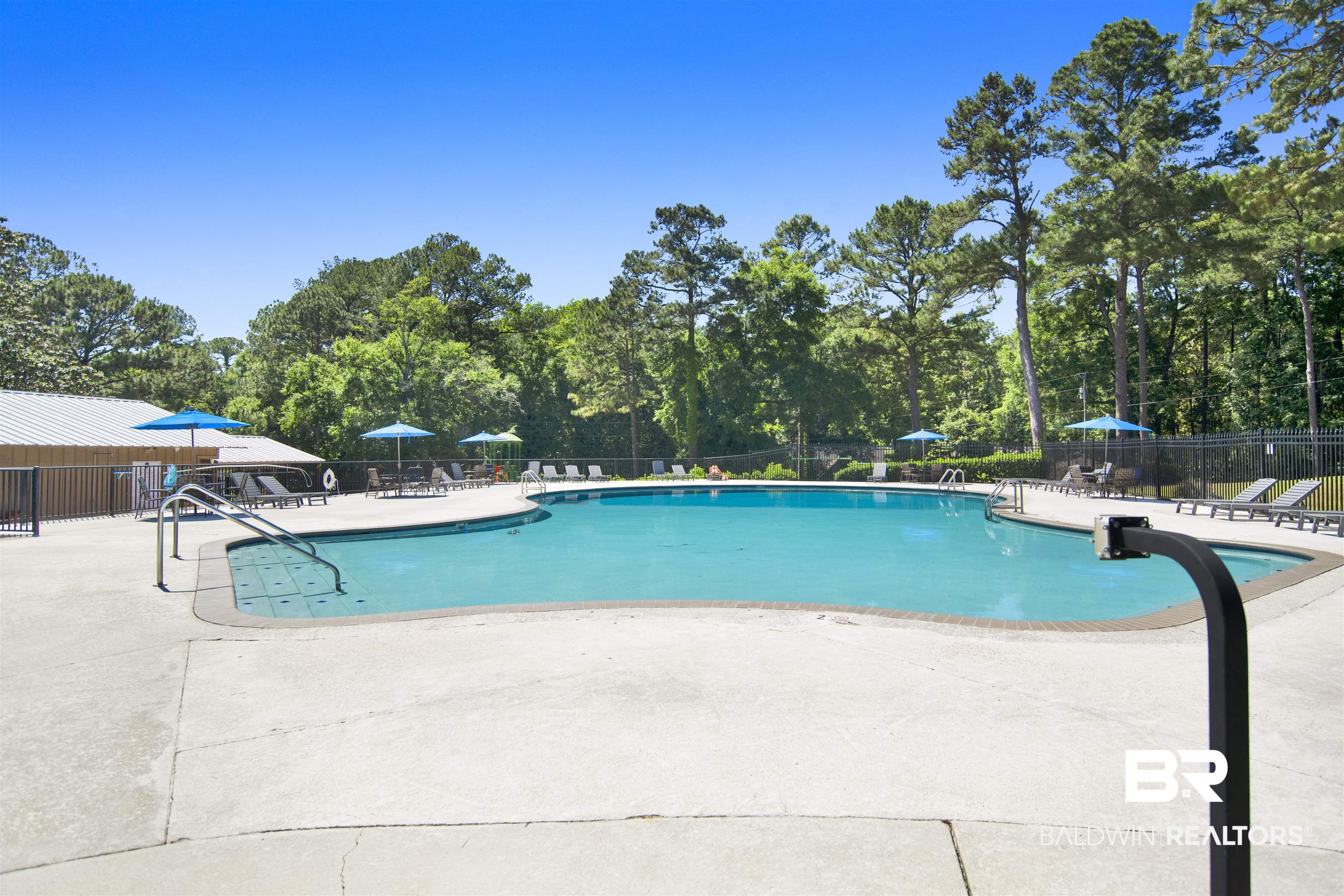 107 Virginia Circle Daphne, AL 36526 - Photo 47 of 47 Outdoor swimming pool with concrete decking, surrounded by mature trees and a privacy fence