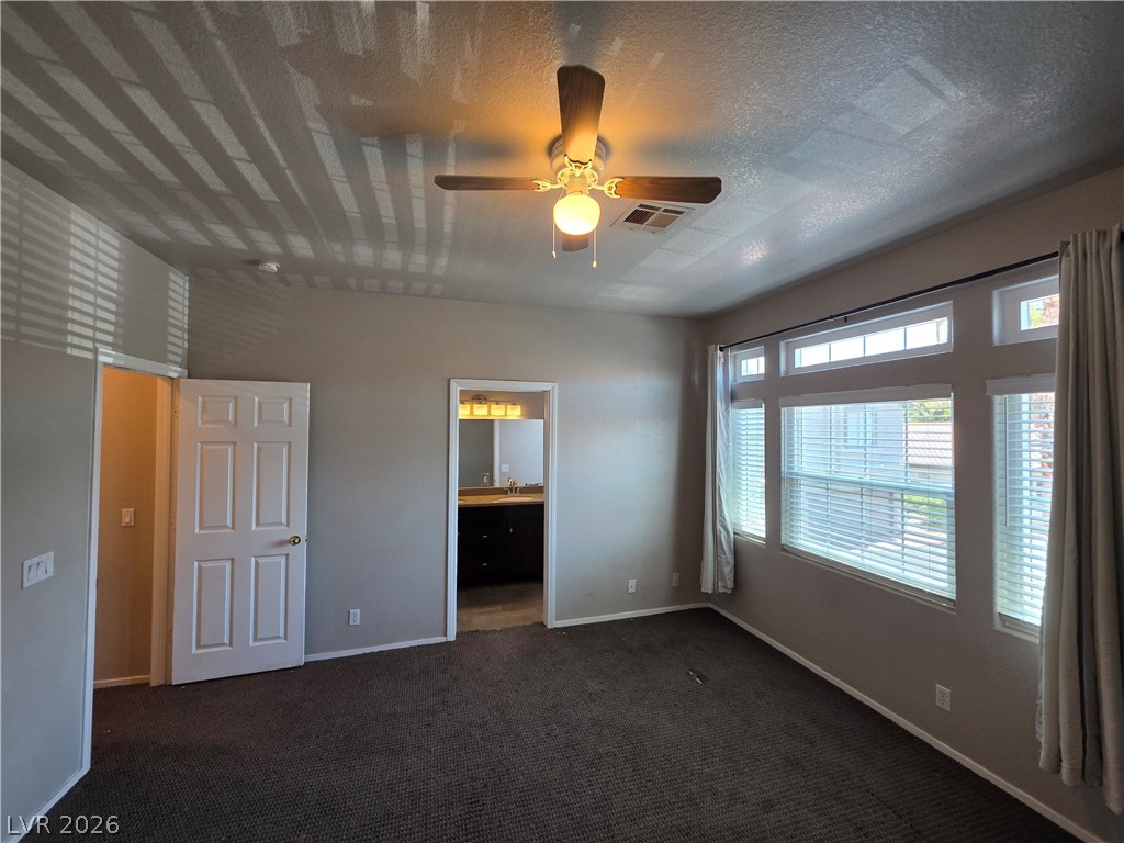 2275 Ramsgate Drive Henderson, NV 89074 - Photo 50 of 84 Well-lit primary bedroom featuring a ceiling fan and convenient access to an en-suite bathroom.