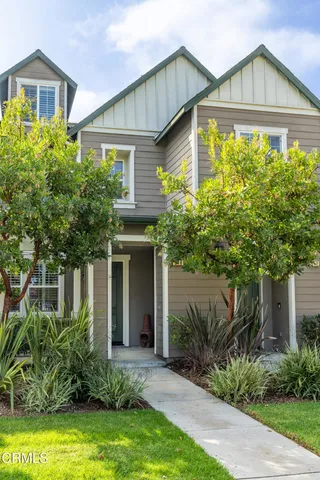 a front view of a house with a yard and plants