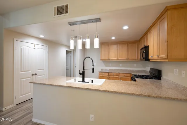 a kitchen with stainless steel appliances granite countertop a sink a stove and a refrigerator