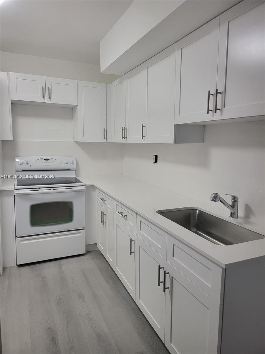 5800 Southwest 127th Avenue, Unit 2105 Miami, FL 33183 - Photo 4 of 5 a kitchen with white cabinets and white appliances