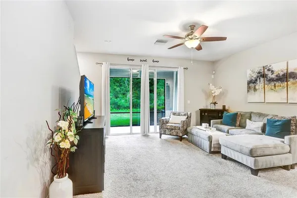 a living room with furniture chandelier and a large window