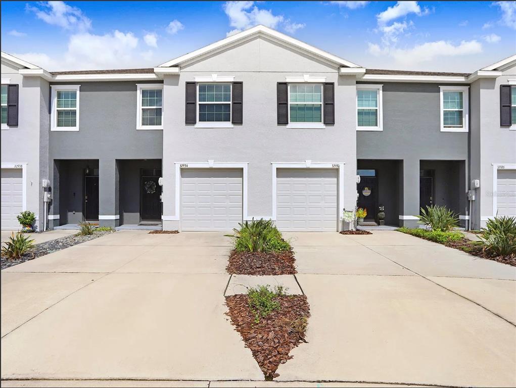 32934 Kaloko Road Wesley Chapel, FL 33543 - Photo 2 of 39 a front view of a house with garden