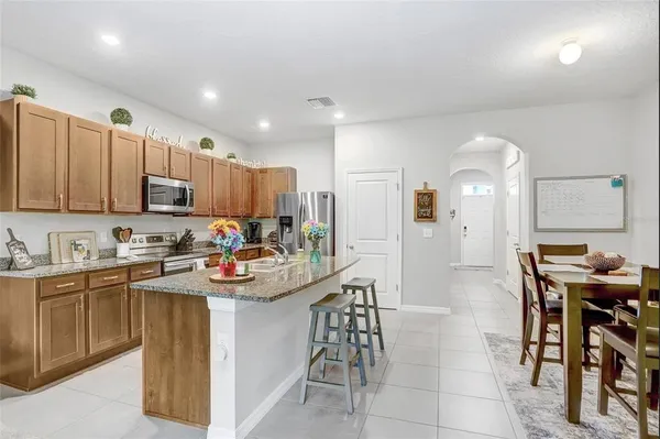 a kitchen with stainless steel appliances granite countertop a table and chairs in it