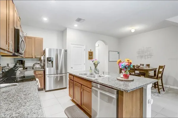 a kitchen with stainless steel appliances granite countertop a sink and a refrigerator