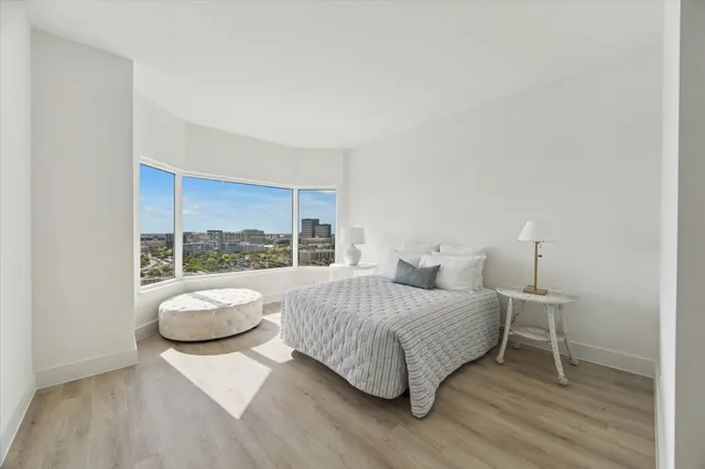 a bedroom with a bed and a large window