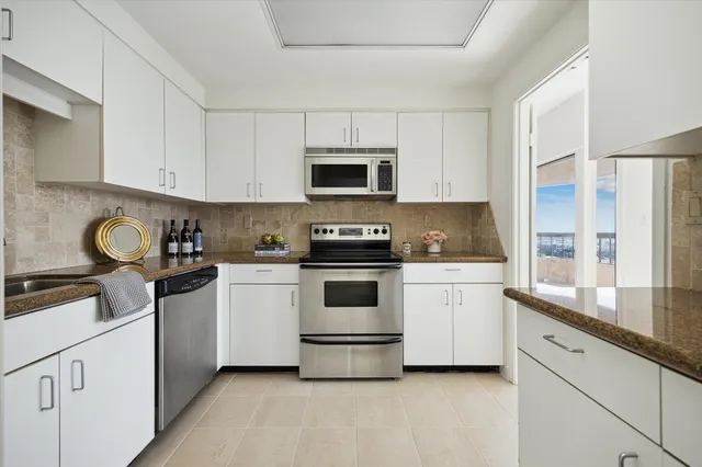 a kitchen with cabinets stainless steel appliances and a sink