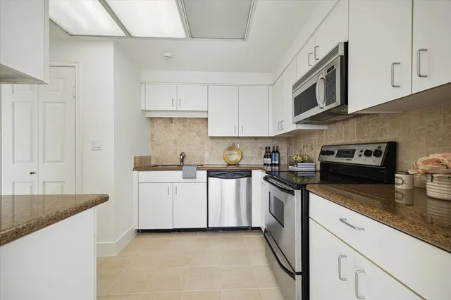 a kitchen with stainless steel appliances granite countertop a sink and dishwasher a stove top oven with wooden floor