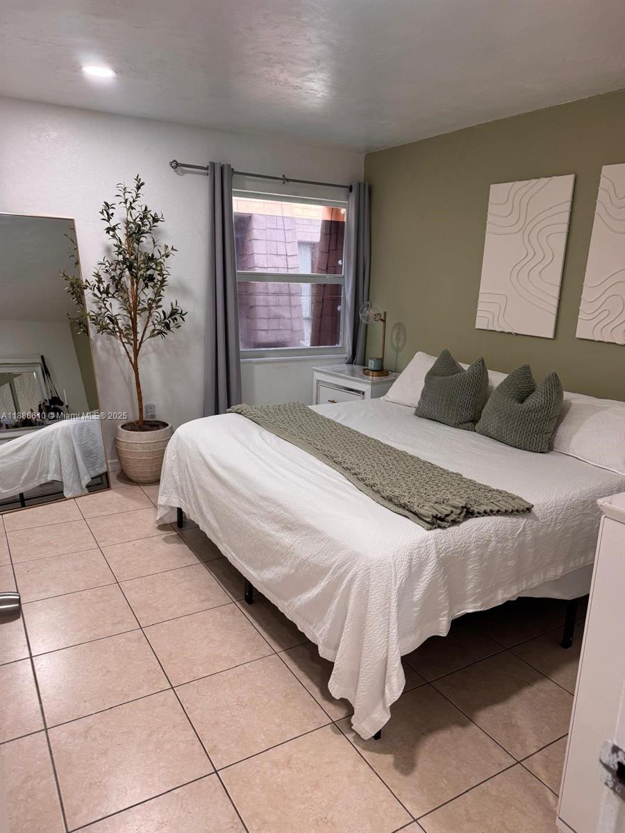 1560 West 46th Street, Unit 236 Hialeah, FL 33012 - Photo 11 of 19 a bedroom with a large bed and a potted plant