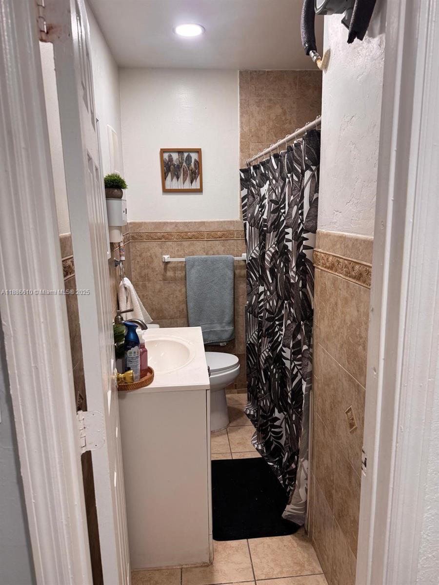 1560 West 46th Street, Unit 236 Hialeah, FL 33012 - Photo 10 of 19 a view of a bathroom with a toilet and a shower curtain