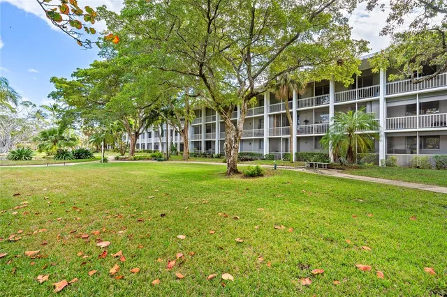 a view of a house with a big yard and large trees