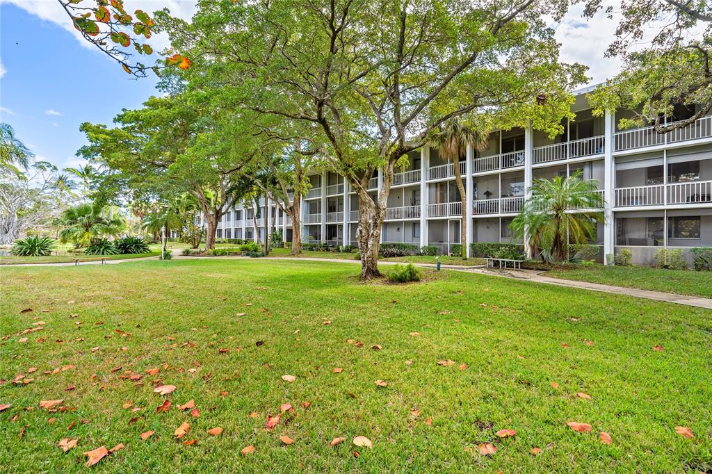 777 Southeast 2nd Avenue, Unit D123 Deerfield Beach, FL 33441 - Photo 23 of 36 a view of a house with a big yard and large trees