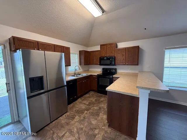 a kitchen with a refrigerator a microwave a sink and a stove