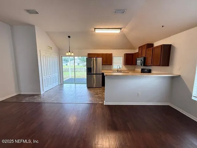 a kitchen with stainless steel appliances a refrigerator and wooden floor