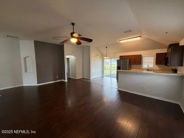 a view of a kitchen with a sink a refrigerator a fireplace and wooden floor
