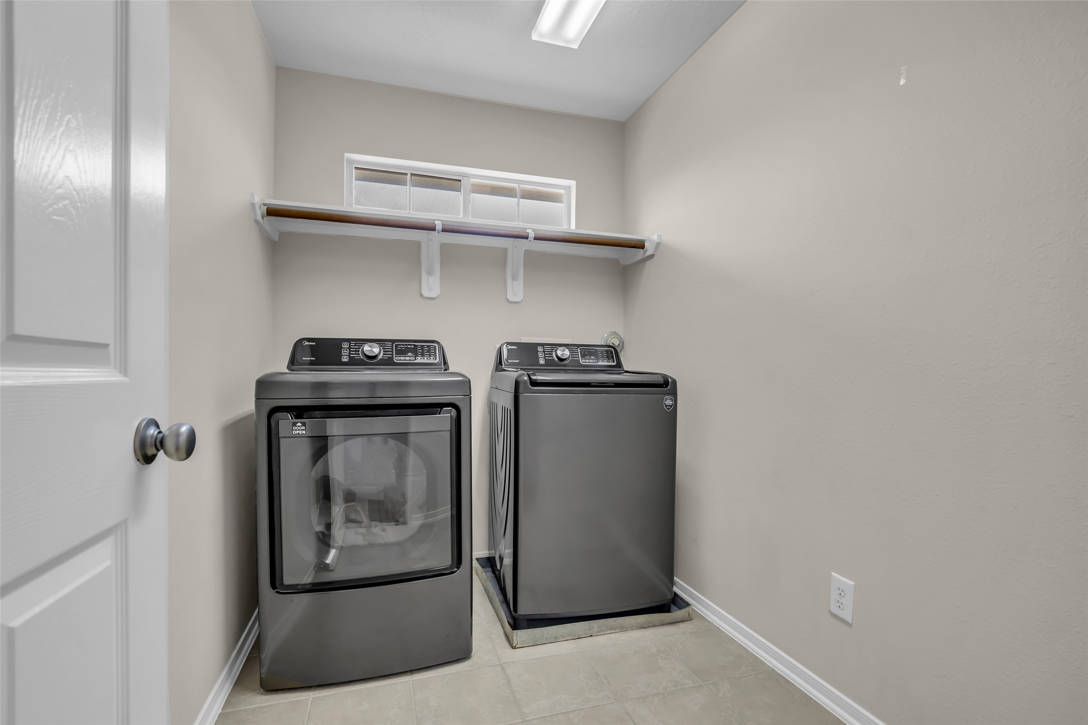 6807 Chapelfield Lane Houston, TX 77049 - Photo 38 of 42 This photo shows a compact laundry room featuring a washer%