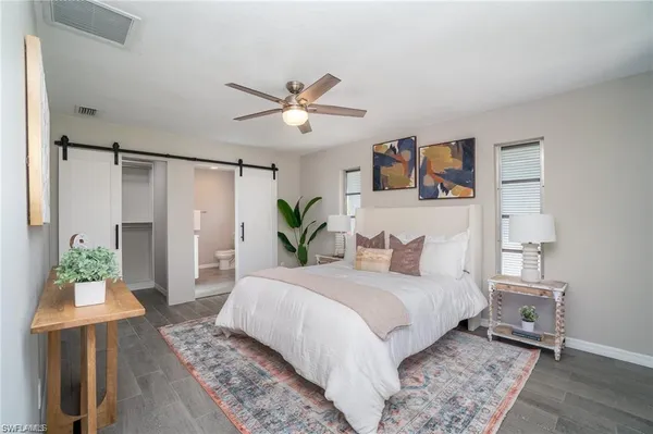 a bedroom with a large bed and a chandelier