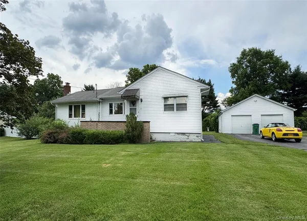 a view of a house with a yard and sitting area