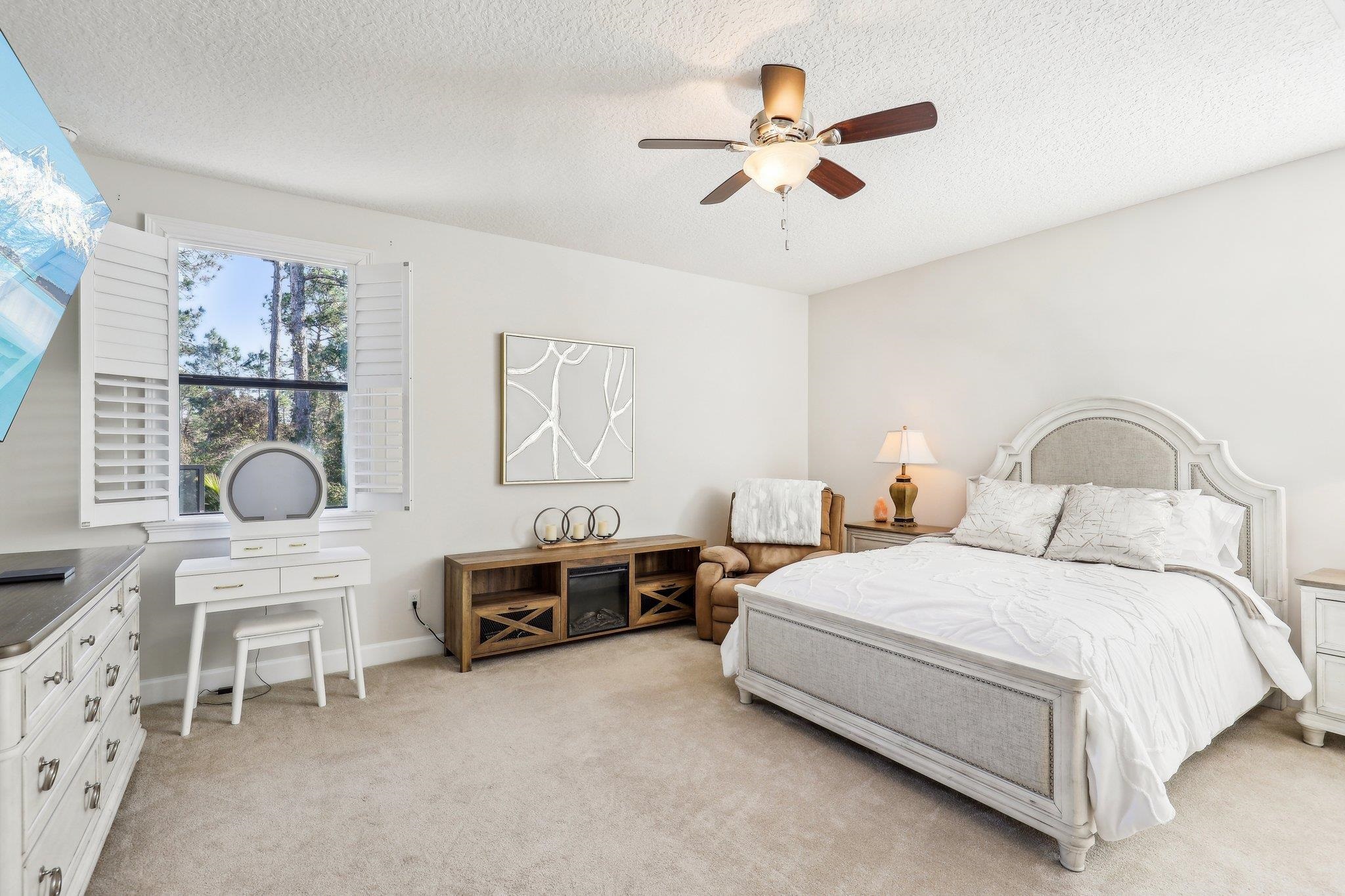 152 Spanish Marsh Drive St. Augustine, FL 32095 - Photo 58 of 63 a bedroom with a bed a chandelier and a dresser