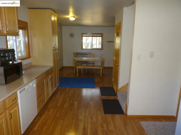 a kitchen with counter top space and wooden floor