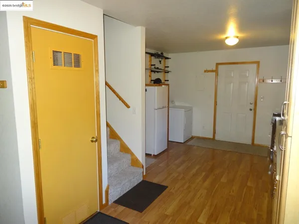 a view of a hallway with wooden floor and entryway