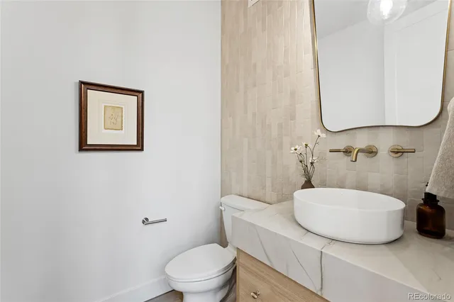 a bathroom with a toilet a sink and mirror