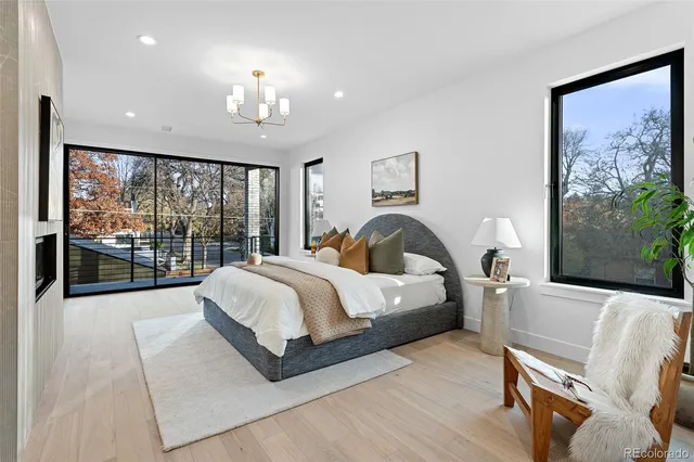 a spacious bedroom with a large bed and a chandelier