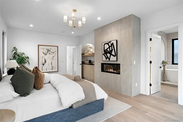 a bedroom with a bed and a chandelier