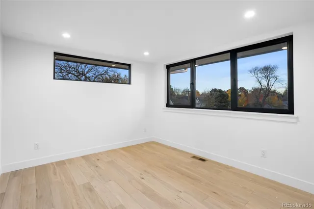a view of a big room with wooden floor and windows