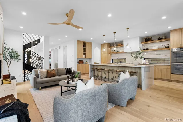 a living room filled with furniture and kitchen view