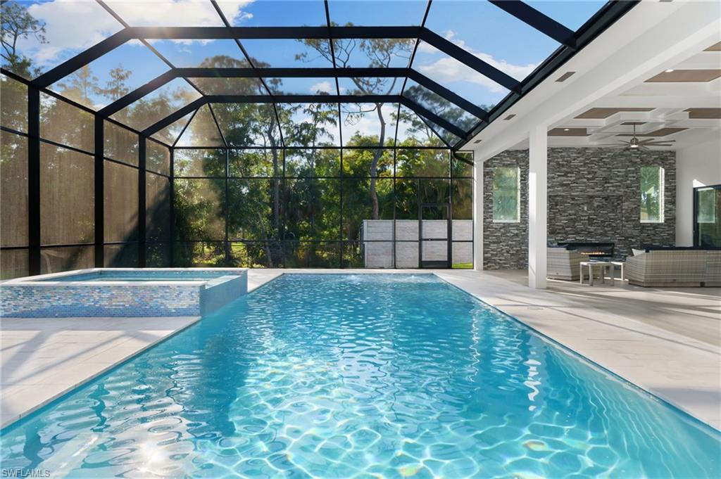 7040 Sable Ridge Lane Naples, FL 34109 - Photo 7 of 50 Private outdoor oasis with an expansive entertainment deck, resort-style pool with tanning shelf and bubbler features, spa