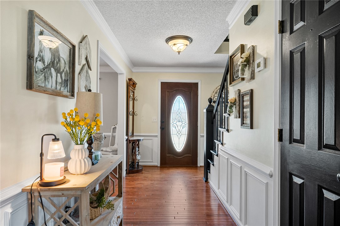 112 C-10-220 Anderson, SC 29621 - Photo 4 of 45 Enter into a bright hallway featuring rich hardwood floors and elegant crown molding.