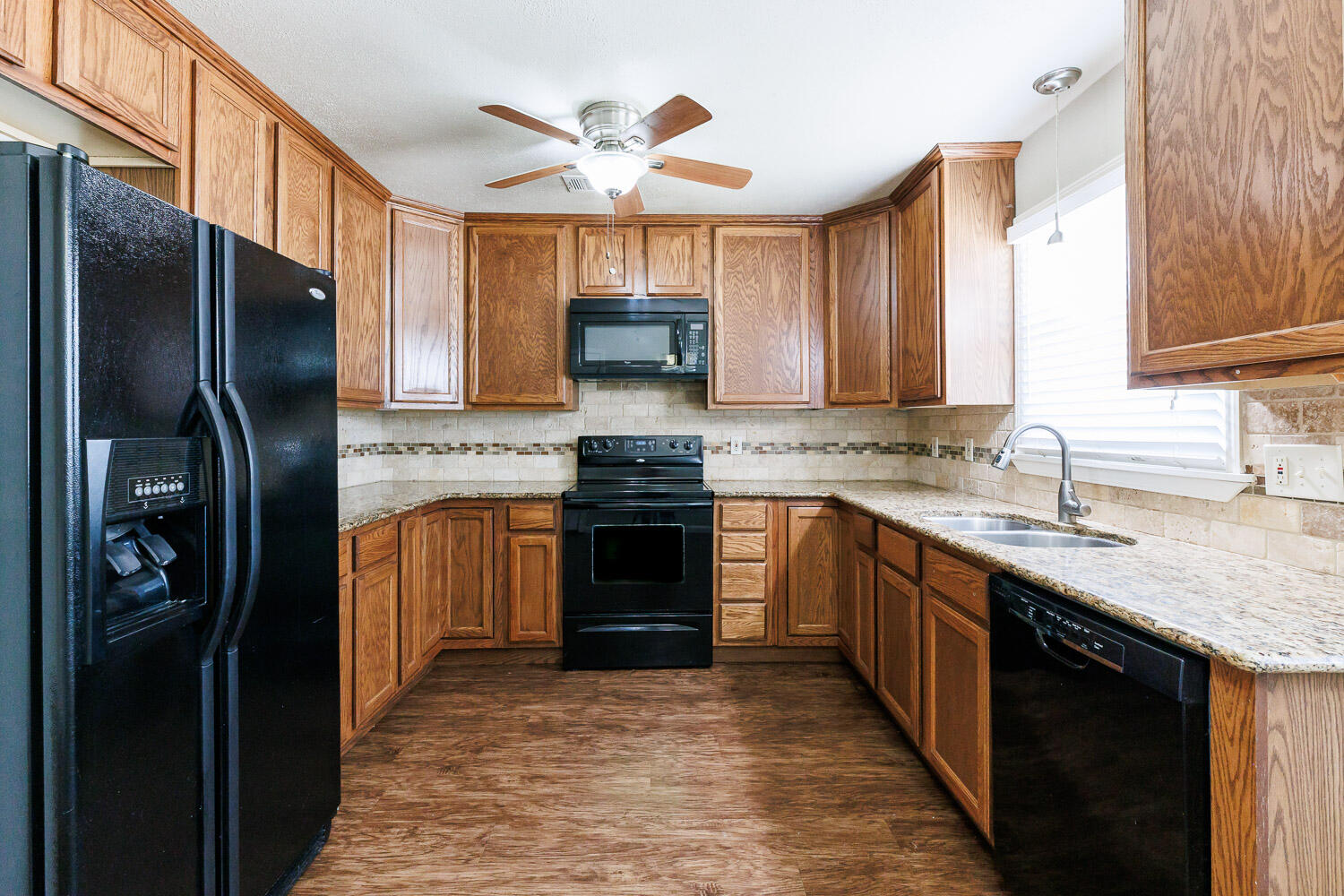 4816 45th Street Lubbock, TX 79414 - Photo 13 of 36 a kitchen with stainless steel appliances granite countertop a refrigerator a stove a sink and a microwave