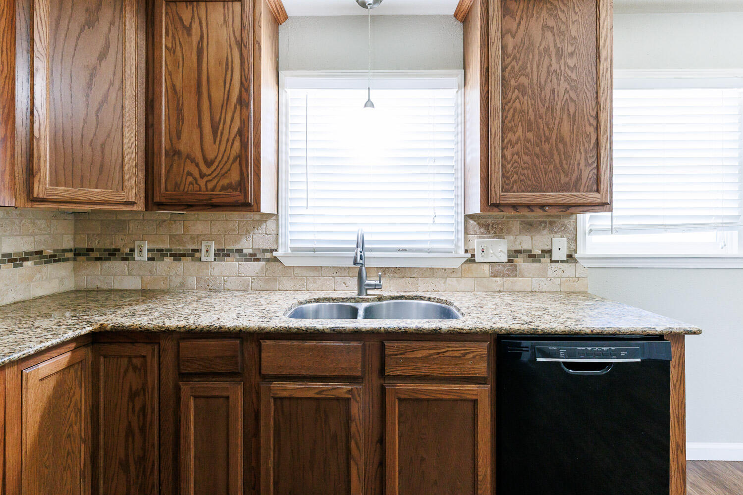 4816 45th Street Lubbock, TX 79414 - Photo 14 of 36 a kitchen with granite countertop a sink and a window