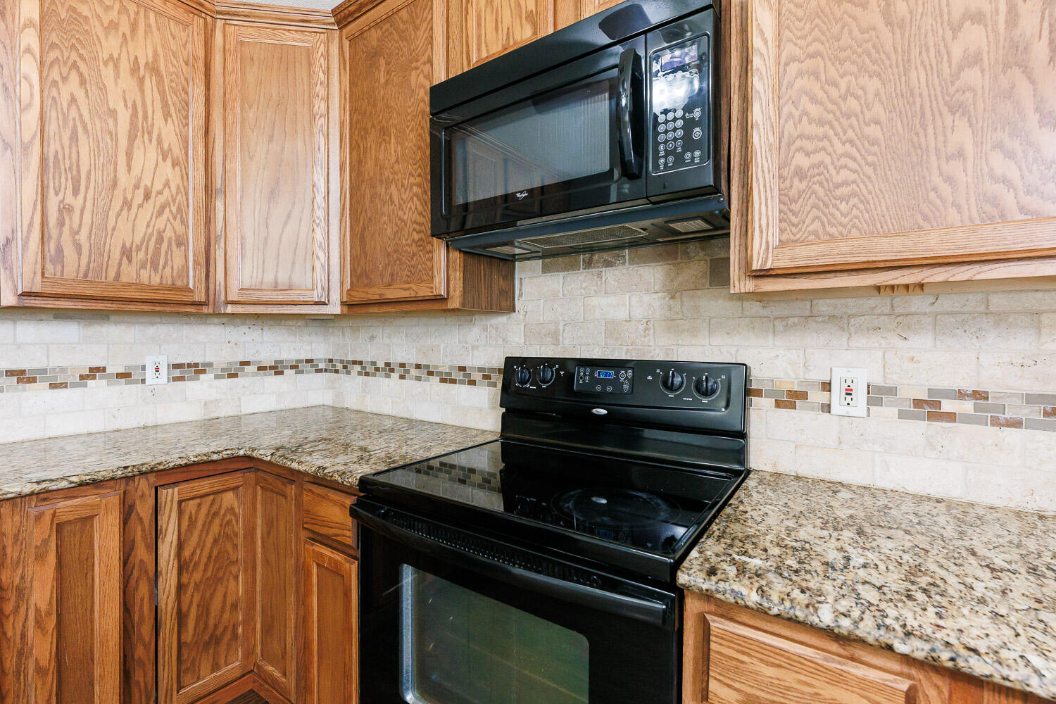 4816 45th Street Lubbock, TX 79414 - Photo 15 of 36 a kitchen with stainless steel appliances granite countertop a stove and a microwave