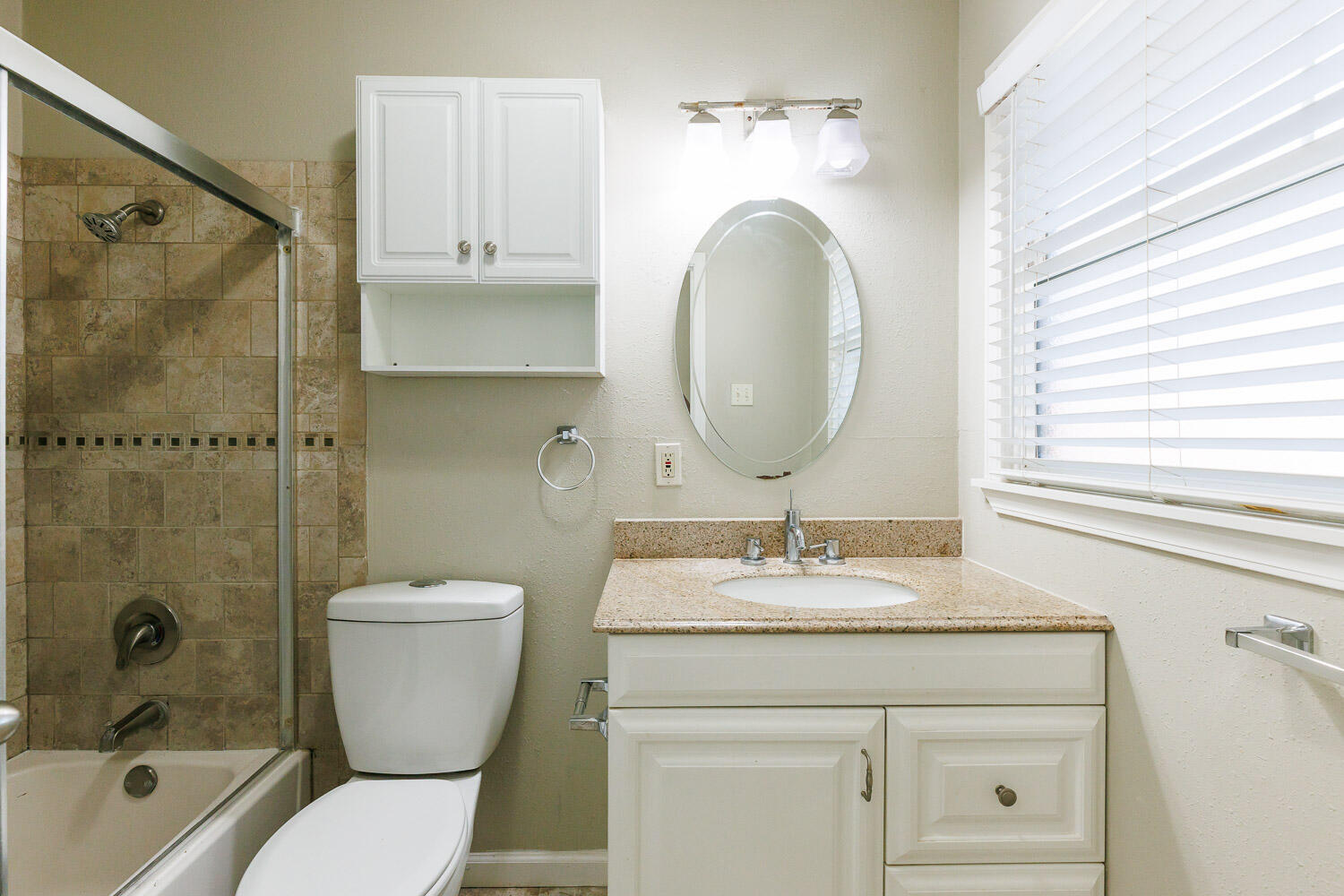 4816 45th Street Lubbock, TX 79414 - Photo 26 of 36 a bathroom with a granite countertop toilet a sink and a mirror