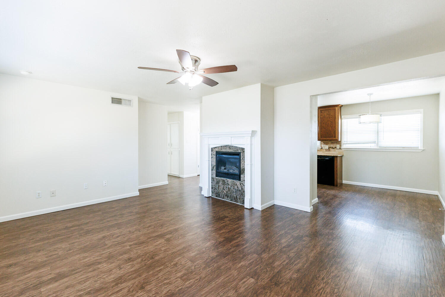4816 45th Street Lubbock, TX 79414 - Photo 9 of 36 an empty room with wooden floor fireplace and windows