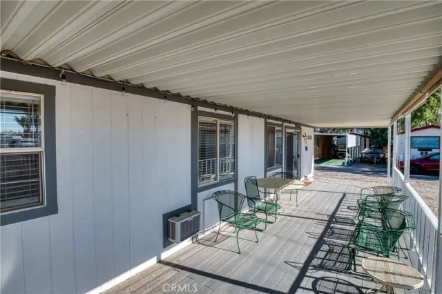 a dining room with stainless steel appliances granite countertop a sink a refrigerator and a fireplace with wooden floor