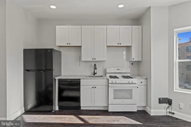 a kitchen with stainless steel appliances granite countertop a sink stove and cabinets